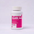 A bottle of PUMPD Vitamin B Complex supplement with a white and pink label, positioned upright against a white background.